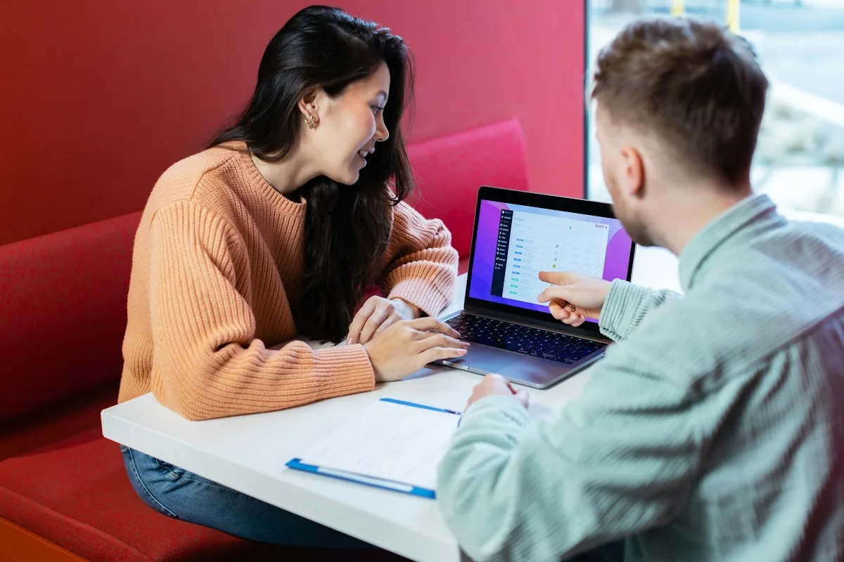 Two people discussing a project at a laptop